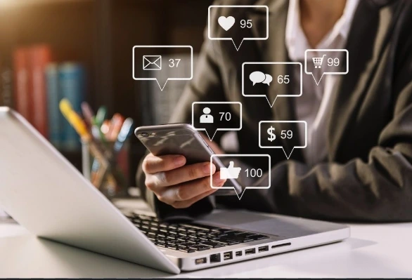 Digital Marketing Contribution to Business Growth Digital Marketing Contribution to Business Growth,A business professional using a smartphone and laptop with floating social media notifications, representing digital marketing engagement and online customer interaction.